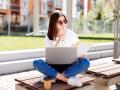 confident-attractive-woman-sitting-bench-park-messaging-social-media-while-writing-notebook-coffee-break