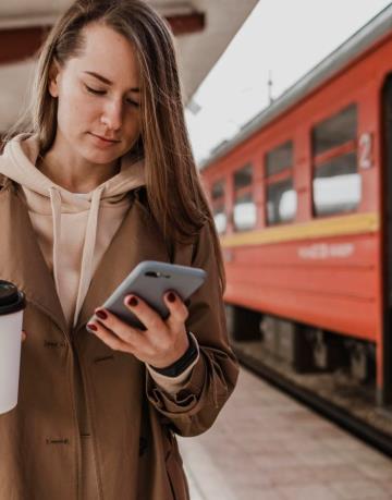 front-view-woman-holding-cup-coffee-train-station