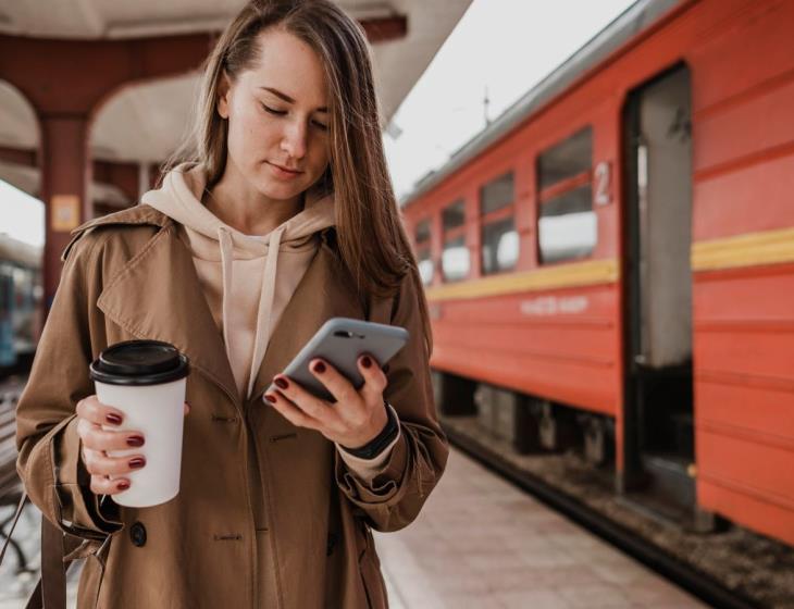 front-view-woman-holding-cup-coffee-train-station